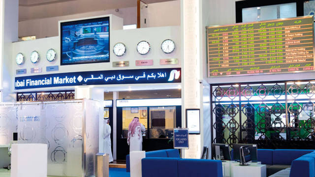 متعاملون يتابعون أسعار الأسهم بقاعة سوق دبي المالي