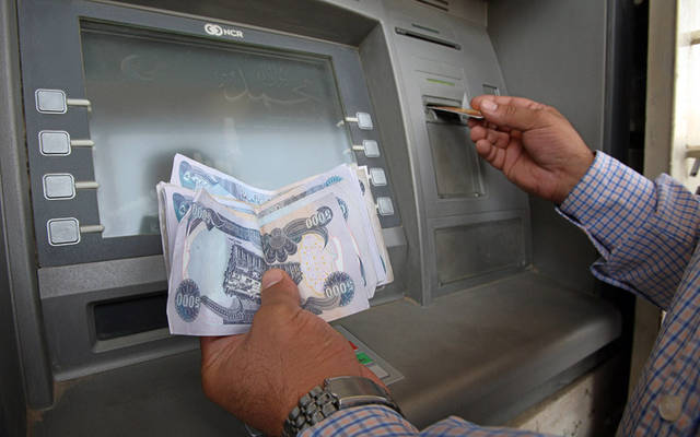 عميل يسحب النقود من ماكينة صراف آلي